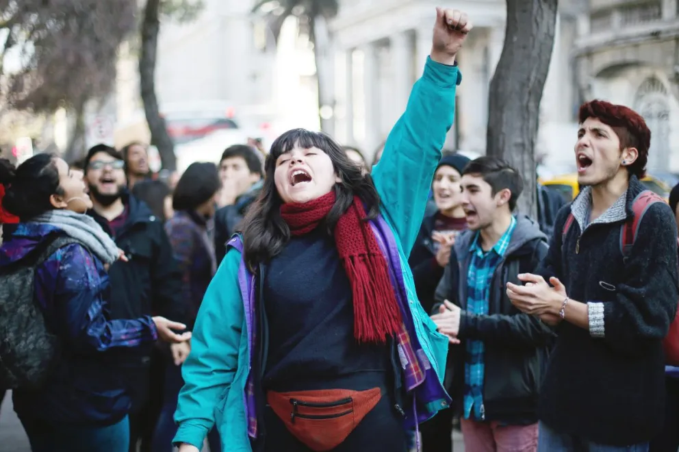 Un grupo de estudiantes se manifiesta en la entrada de la sede del Congreso en Santiago en contra de la iniciativa, que a su juicio mantiene el criterio de mercado y del lucro en la enseñanza universitaria