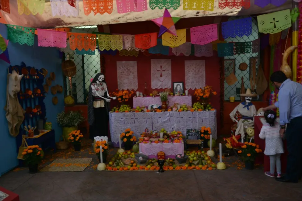 Un padre muestra a su hija los llamados altares de la muerte en el museo de la cultura en Coayacán