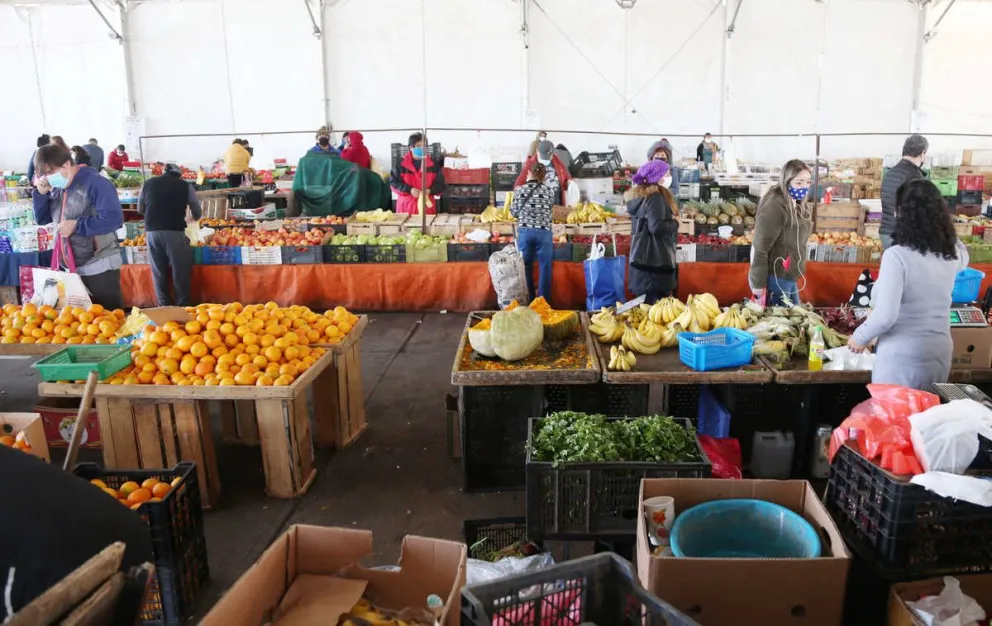 En la Feria Frutos del Norte, de la Avenida Costanera de Coquimbo hay control de acceso al recinto y toma de temperatura a los clientes. Se ve orden y mantención de distancia.