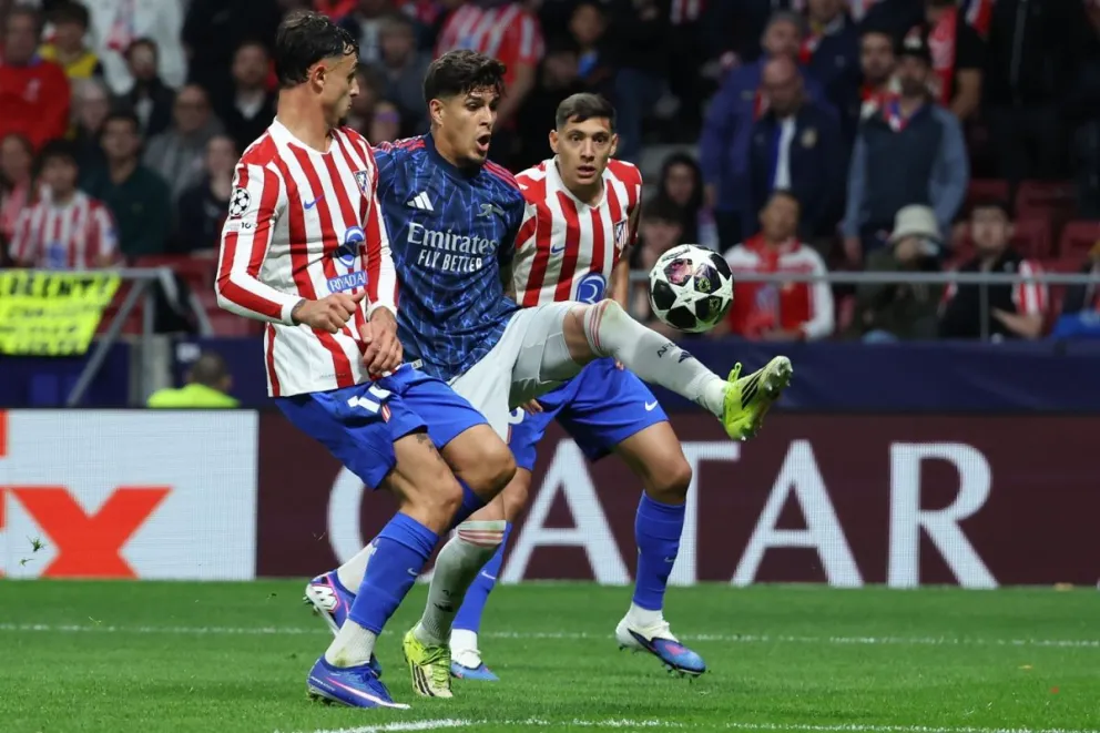 El defensa colombiano del Arsenal Piero Hincapie intenta controlar el balón ante el defensa del Atlético de Madrid, Marc Pubill. (Foto: EFE)